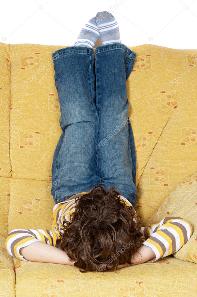 Boy lying down on the sofa at home