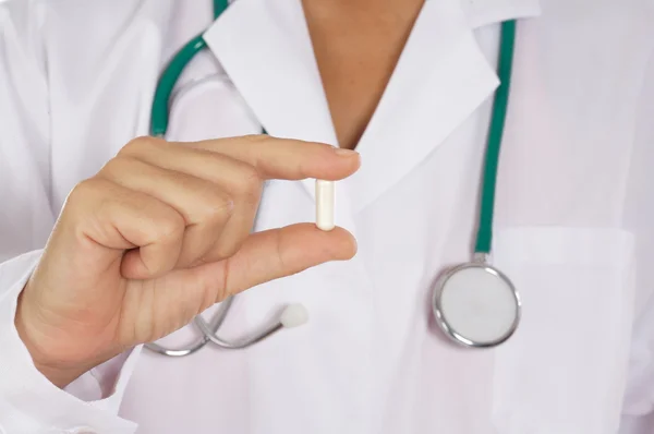 Doktor s uniforma drží jednu pilulku — Stock fotografie