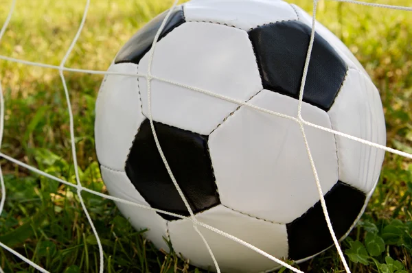 Fotbalový míč v brankové síti — Stock fotografie