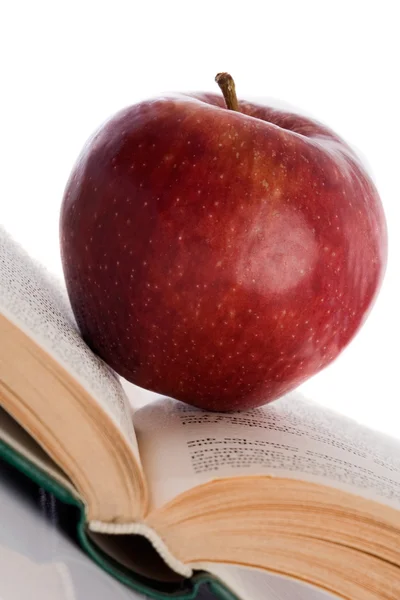Manzana roja en libro abierto inclinado —  Fotos de Stock