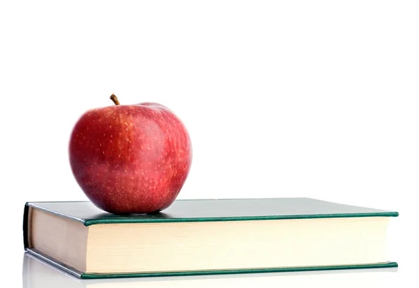 Una mela rossa rossa su un libro verde — Foto Stock