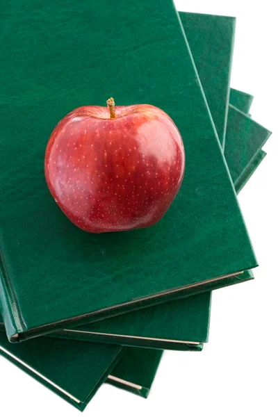 Uma maçã vermelha vermelha em um livro verde — Fotografia de Stock