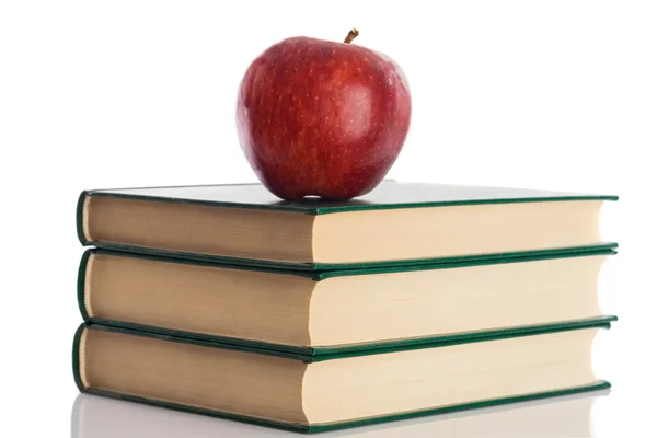 Uma maçã vermelha em cima de três livros — Fotografia de Stock
