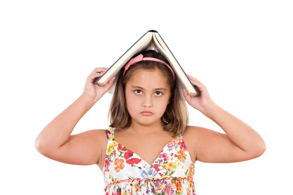 Menina adorável estudando com um livro na cabeça — Fotografia de Stock