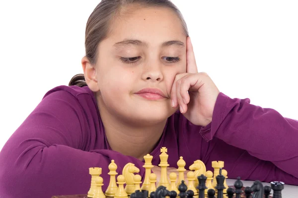 Привлекательная маленькая девочка играет в шахматы — стоковое фото