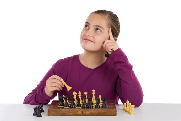 Привлекательная маленькая девочка играет в шахматы — стоковое фото