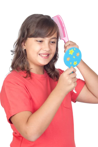 Preteen girl combing with a comb in front of a mirror — Stock Photo, Image