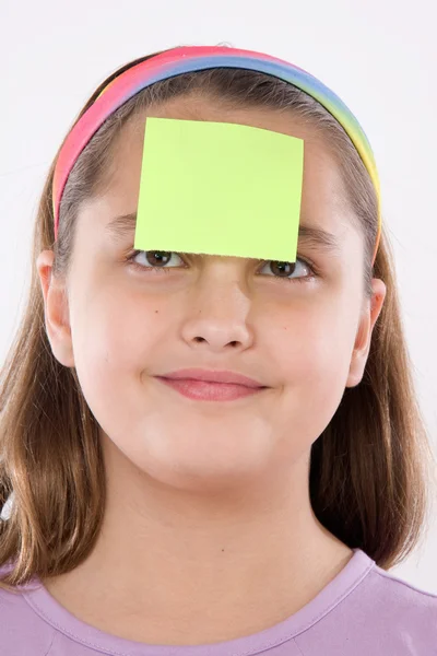 Entzückendes Mädchen mit einem Zettel vor der Nase — Stockfoto