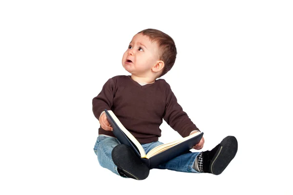 Hermoso bebé con un libro llorando — Stockfoto