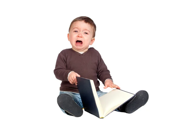 Bebê bonito com um livro chorando — Fotografia de Stock