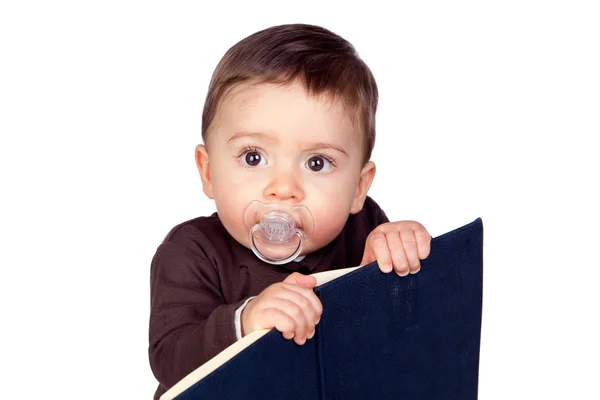 Mooie baby met een fopspeen lezen — Stockfoto