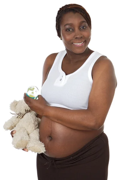 Mulher grávida atraente dando a mamadeira do bebê a um bebê urso — Fotografia de Stock
