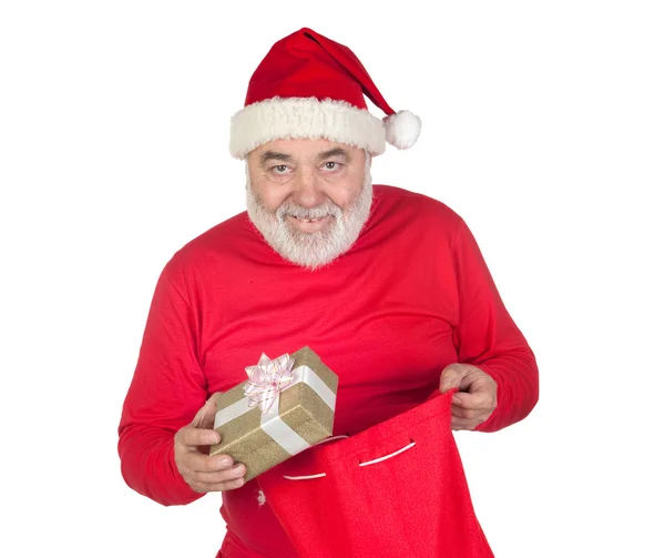 Lustiger Weihnachtsmann nimmt ein Geschenk aus seinem Sack — Stockfoto