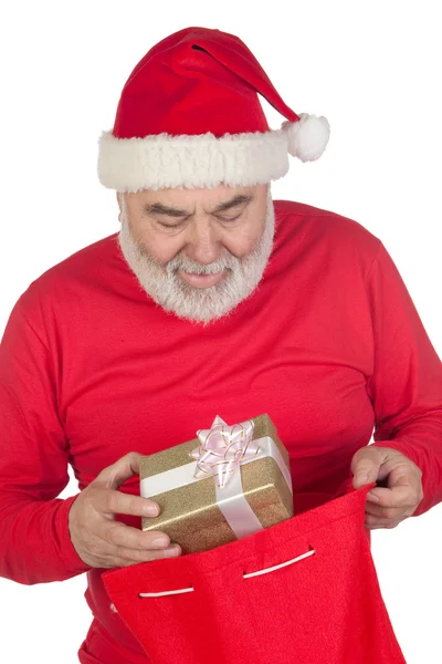 Engraçado Papai Noel tomando um presente de seu saco — Fotografia de Stock
