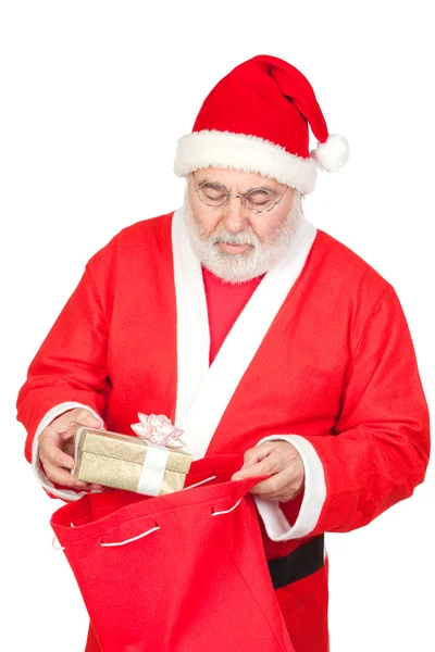 Santa claus coraz prezent od jego worek — Zdjęcie stockowe