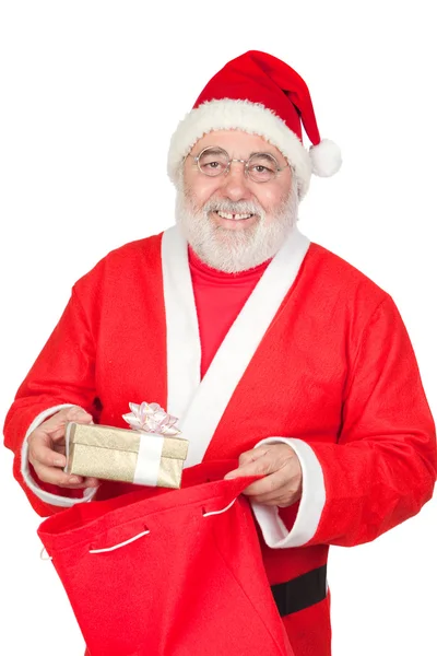 Papai Noel recebendo um presente de seu saco — Fotografia de Stock