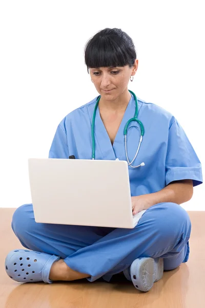 Женщина-врач сидит с ноутбуком — стоковое фото