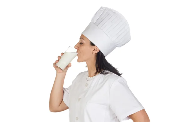 Гарненька кухарка п'є молоко — стокове фото