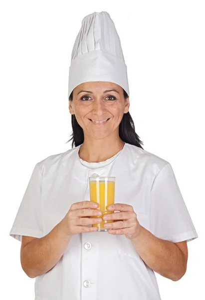 Menina cozinheiro bonita com um copo de suco de laranja — Fotografia de Stock