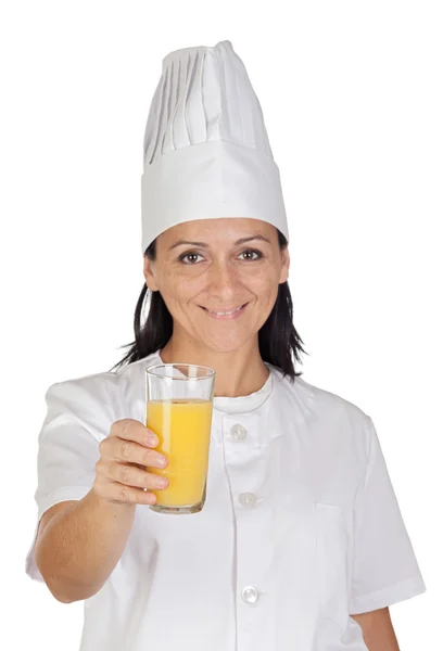 Pretty cook girl with a glass of orange juice — Stock Photo, Image