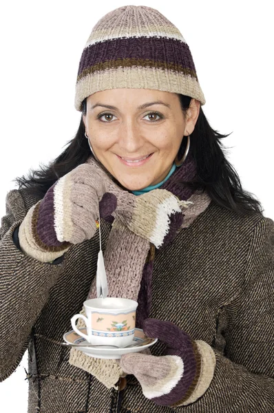 Attractive lady sheltered for the winter drinking a tea cup Royalty Free Stock Images