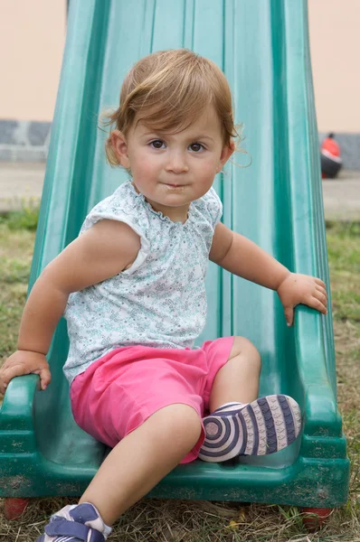 Menina jogando em um slide — Fotografia de Stock