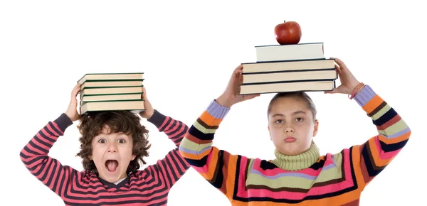 Adorables niños con muchos libros y manzana en la cabeza — Foto de Stock