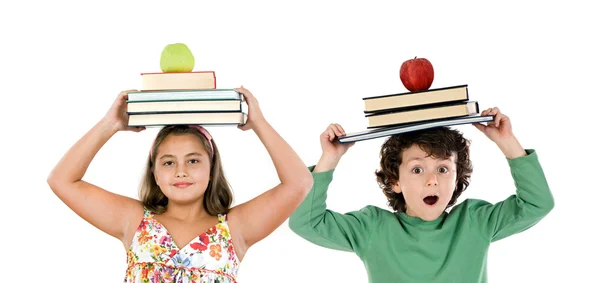 Adorables niños con muchos libros y manzana en la cabeza —  Fotos de Stock