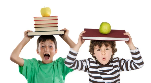 Crianças adoráveis com muitos livros e maçã na cabeça — Fotografia de Stock