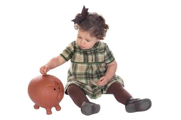Mädchen steckt eine Münze in ein Sparschwein — Stockfoto