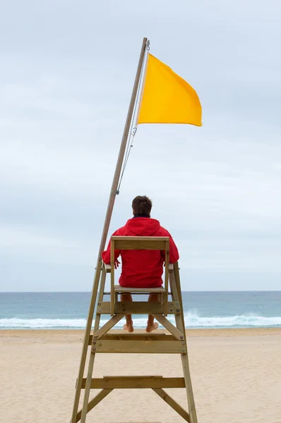 Lifeguard sitting in his chair — Stock Photo, Image