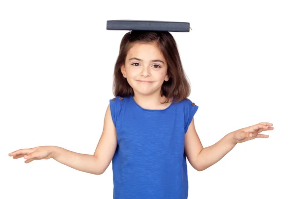 Brünettes kleines Mädchen mit einem Buch auf dem Kopf — Stockfoto