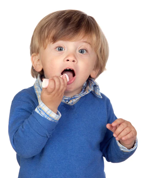Hermoso bebé con camiseta azul comiendo un dulce — Foto de Stock