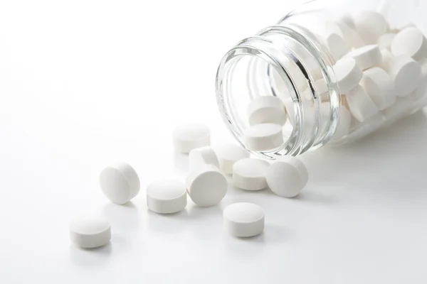 Таблетки, що виливаються з пляшки таблеток — стокове фото