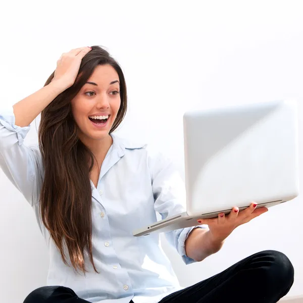 Chica sosteniendo portátil con mirada sorprendida — Foto de Stock