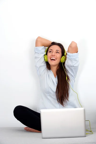 Joyeux jeune femme avec ordinateur portable et écouteurs — Photo