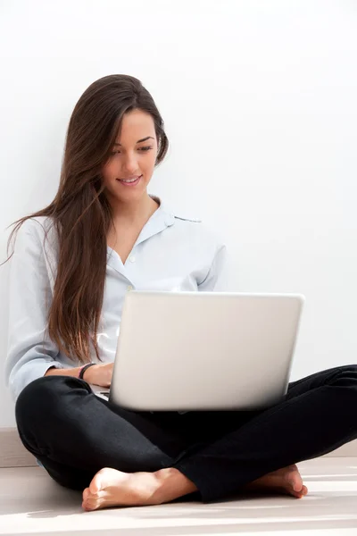 Ung kvinna som arbetar på bärbar dator — Stockfoto