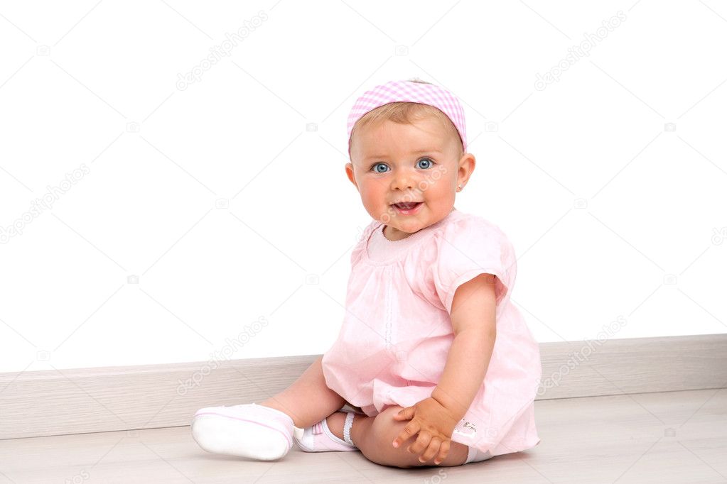 Baby girl with blue eyes sitting on the floor