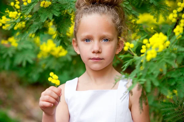 Aranyos lány a kerti virágok. — Stock Fotó
