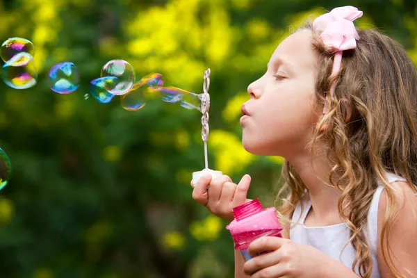 Mladá dívka foukání bublin. — Stock fotografie