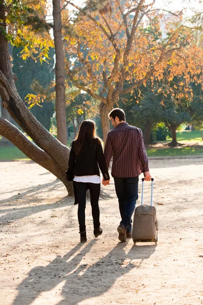 情侣在公园与旅游推车行走. — 图库照片
