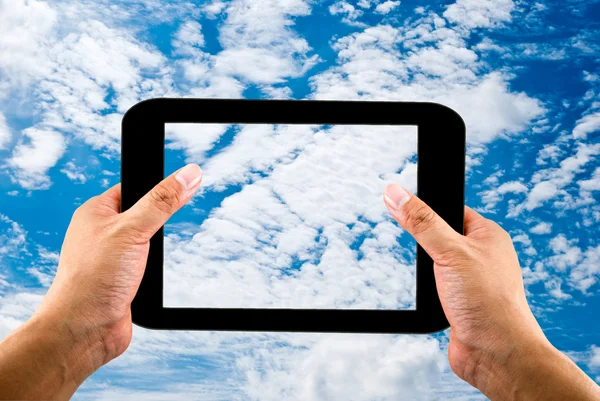 Tablet in handen op blauwe hemelachtergrond — Stockfoto