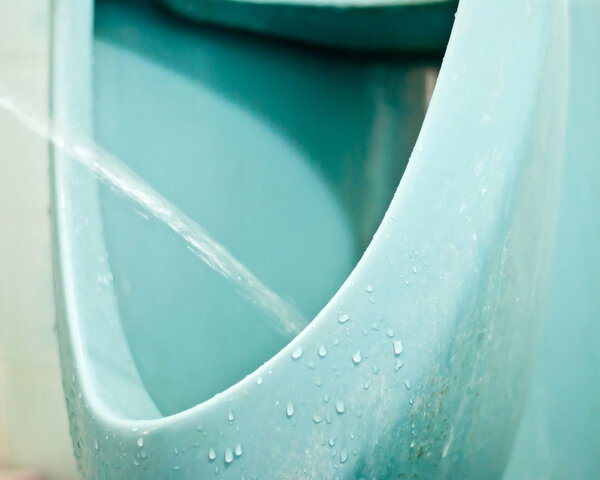 Мужчина писает на лобковый писсуар
