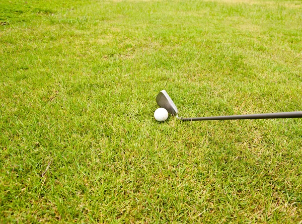 Clube de golfe de ferro e bola de golfe na grama verde — Fotografia de Stock