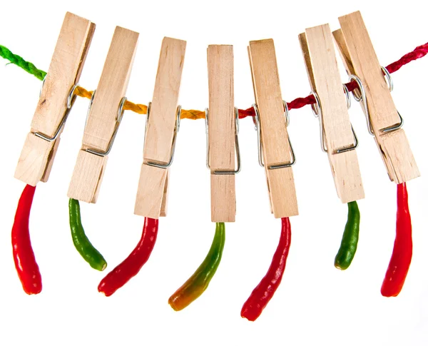 Πιπεριές τσίλι που κρέμονται στο πολύχρωμο σχοινί με ξύλινα ρούχα καρφίτσα — Φωτογραφία Αρχείου