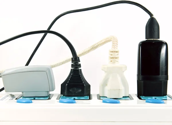 Many plugs plugged into electric power bar — Stock Photo, Image