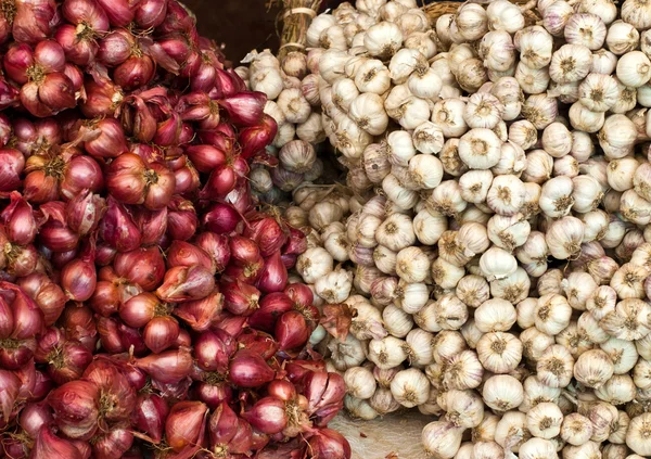 Stock image Shallots and garlic stacked on a market