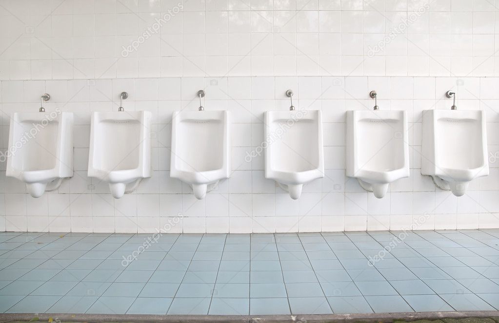 A row of urinals in tiled wall in a public restroom — Stock Photo ...