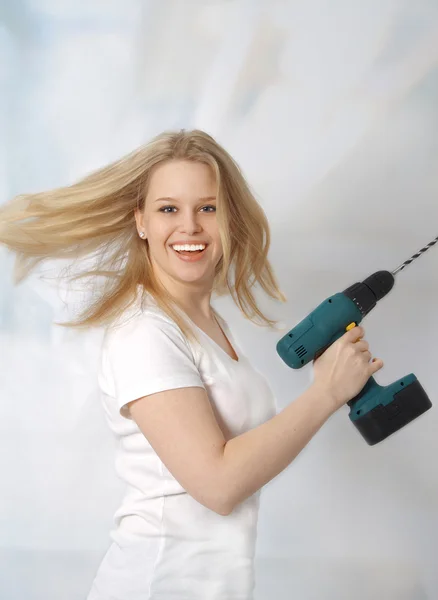 Portrait of happy young woman posing with a drill — Stock Photo, Image