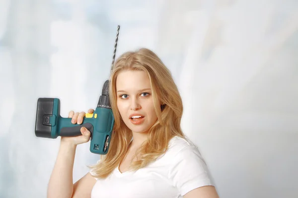 Portrait of happy young woman posing with a drill Royalty Free Stock Images
